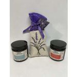 Two scented candles flank a lavender sachet gift bag.