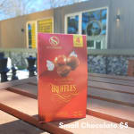 Box of milk chocolate truffles on a wooden table