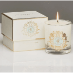 Lit white candle in a glass tumbler beside a matching box