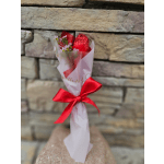 Small wrapped bouquet with red foil and pink flowers tied with a red ribbon