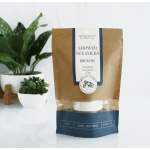 Package of shower steamers beside two potted plants