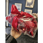 Clear gift box with red rose petals and a red ribbon bow