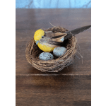 Decorative bird nest with a yellow bird and speckled eggs