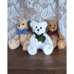 Three plush teddy bears with ribbon bows sitting together