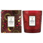 Two red Voluspa candles, one in a patterned box and one in a glass jar.
