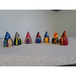 Seven small painted gnome figurines lined up on a tabletop