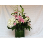 Pink lilies and white hydrangea in a green glass vase