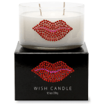 White candle in a glass jar on a black box with a jeweled lips design
