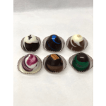 Set of six assorted round chocolate truffles in individual paper cups on a white surface