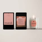 Three pink-scented candles in black and clear glass containers
