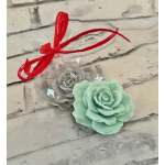 Two rose-shaped decorative items tied with a red ribbon