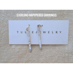 Pair of hammered silver drop earrings on a jewelry card