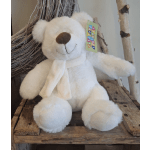 White plush teddy bear with a scarf sitting on a rustic wooden shelf