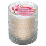 Scented candle in a textured glass holder with a floral lid label