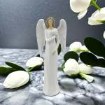 White angel figurine surrounded by white flower buds