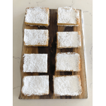 Rectangular powdered sugar dessert bars arranged on a wooden board.