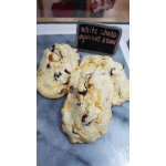 Three white chocolate apricot scones on a gray marble slab with a small chalkboard label.