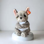 Plush gray French bulldog toy sitting on a white base