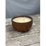 Brown bowl candle with three wicks on a weathered wooden surface