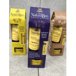 Three Naked Bee lotion gift sets in yellow, purple, and brown boxes