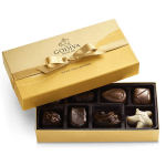Gold rectangular chocolate box with ribbon, partially open to show assorted chocolates inside