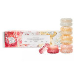 Rose-themed candle gift set with pastel faceted glass jars stacked beside a floral-printed box.