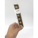 Hand holding a box of gold-wrapped chocolates