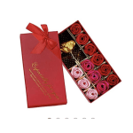 Red gift box with ribbon holding roses and chocolates