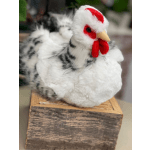 A black-and-white chicken figurine sits on a wooden block.