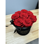 Red roses arranged in a black round box with a ribbon bow