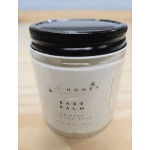 Jar candle with a black lid on a light wood surface