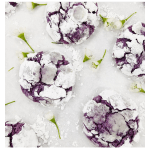 Purple crinkle cookies coated in powdered sugar with small white blossoms scattered around.