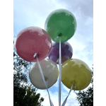 Cluster of colorful balloons with white ribbons against the sky