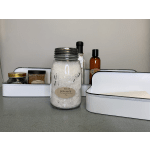 Bath salts jar with assorted spa gift items in white trays