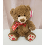 Brown teddy bear with a red heart-patterned bow and heart paw pads