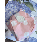 Pink polka-dot wrapped gift with a round white tag on floral paper