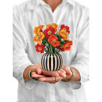Small striped vase with bright red and orange flowers