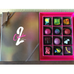 Gift box of assorted colorful artisan chocolates in a black and pink box