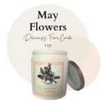 White jar candle with floral illustration label and separate lid on a light circular background.