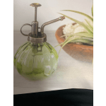 Green glass plant mister with a metal spray nozzle