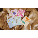 Five floral greeting cards on a gold satin fabric