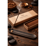 Incense stick burning in a holder beside boxed incense sticks
