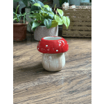 Small red-and-white mushroom-shaped ceramic vase on a wooden surface
