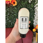 Hand holding a bottle of Cherry Almond goat milk lotion