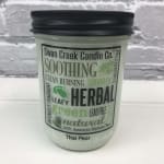 Jar candle with a black lid and herbal label