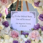 Pastel floral wreath with a memorial sign on an easel