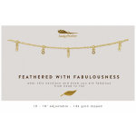 Gold chain necklace with small feather and crystal charms displayed on a white card with printed text.