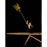 Tall yellow floral stem arrangement in a dark glass vase