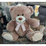 Plush teddy bear with a pink ribbon bow