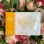 Box of milk chocolates resting on a pink floral arrangement